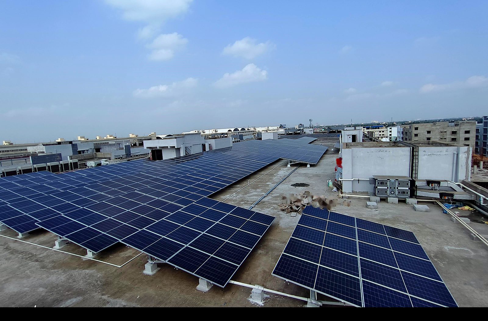Wide view of rooftop solar arrays on an industrial building